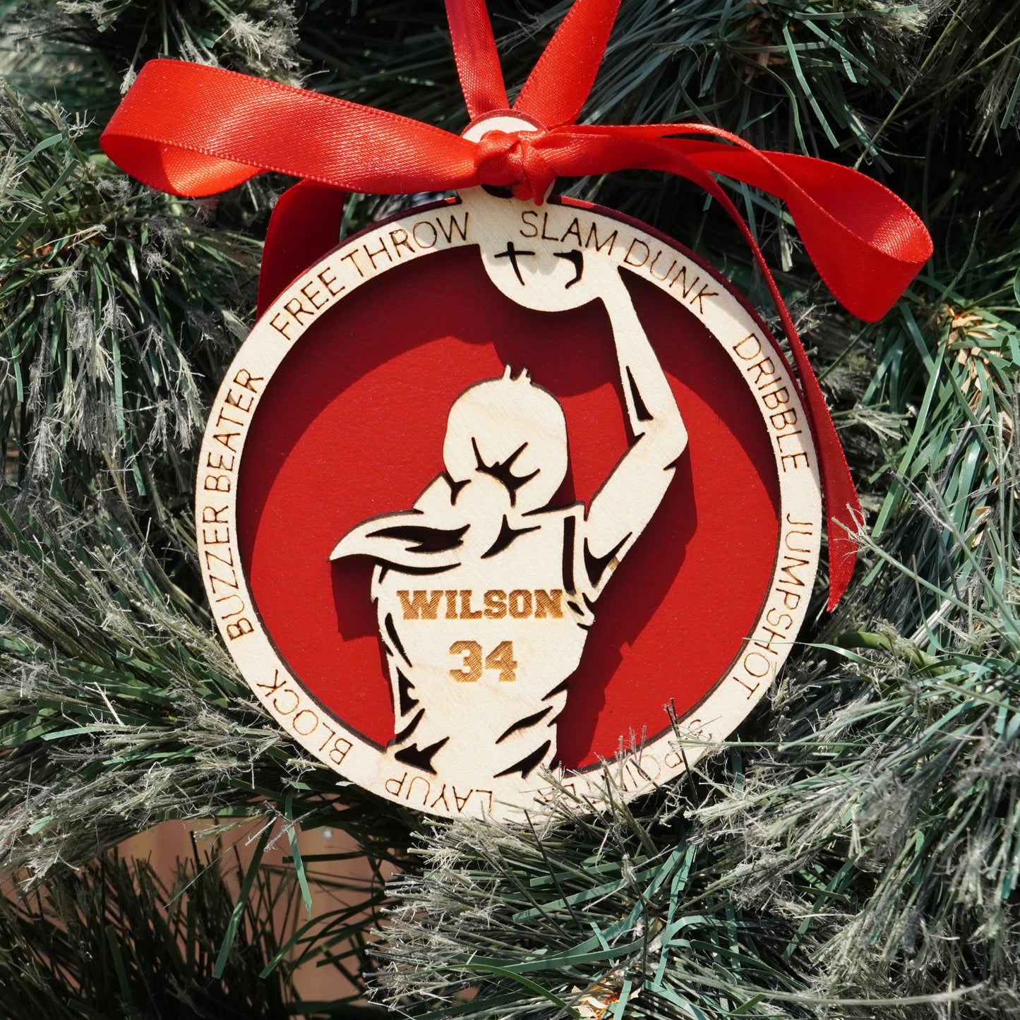 Basketball-themed ornament with a red ribbon on a Christmas tree