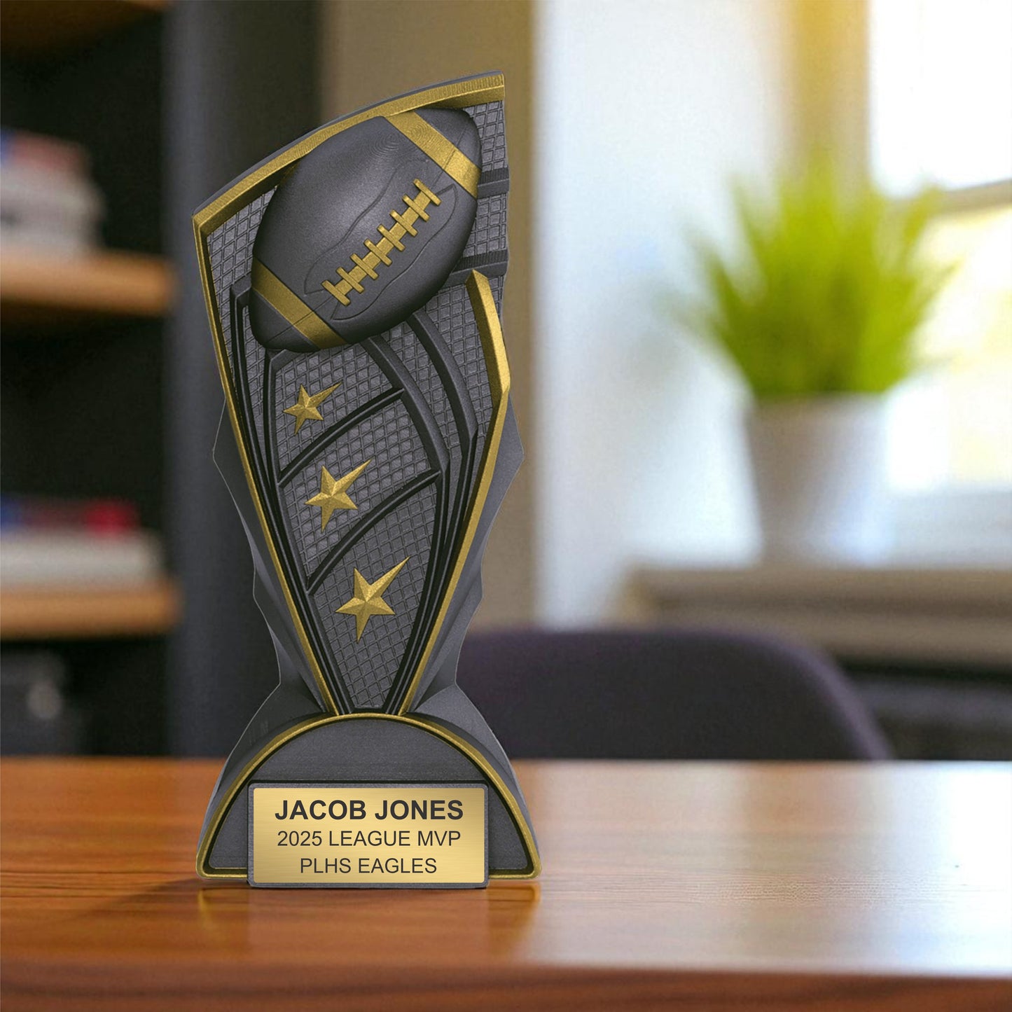 Trophy with football design on a wooden surface, featuring engraved text.