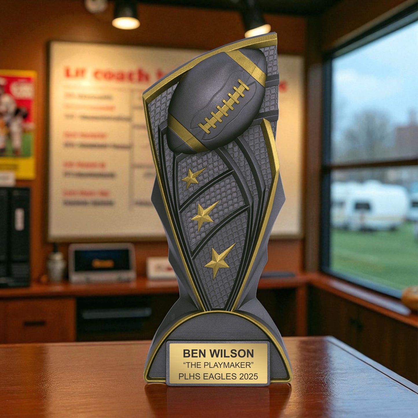 Trophy with football design on a wooden surface, featuring the name 'Ben Wilson' and 'The Playmaker'.