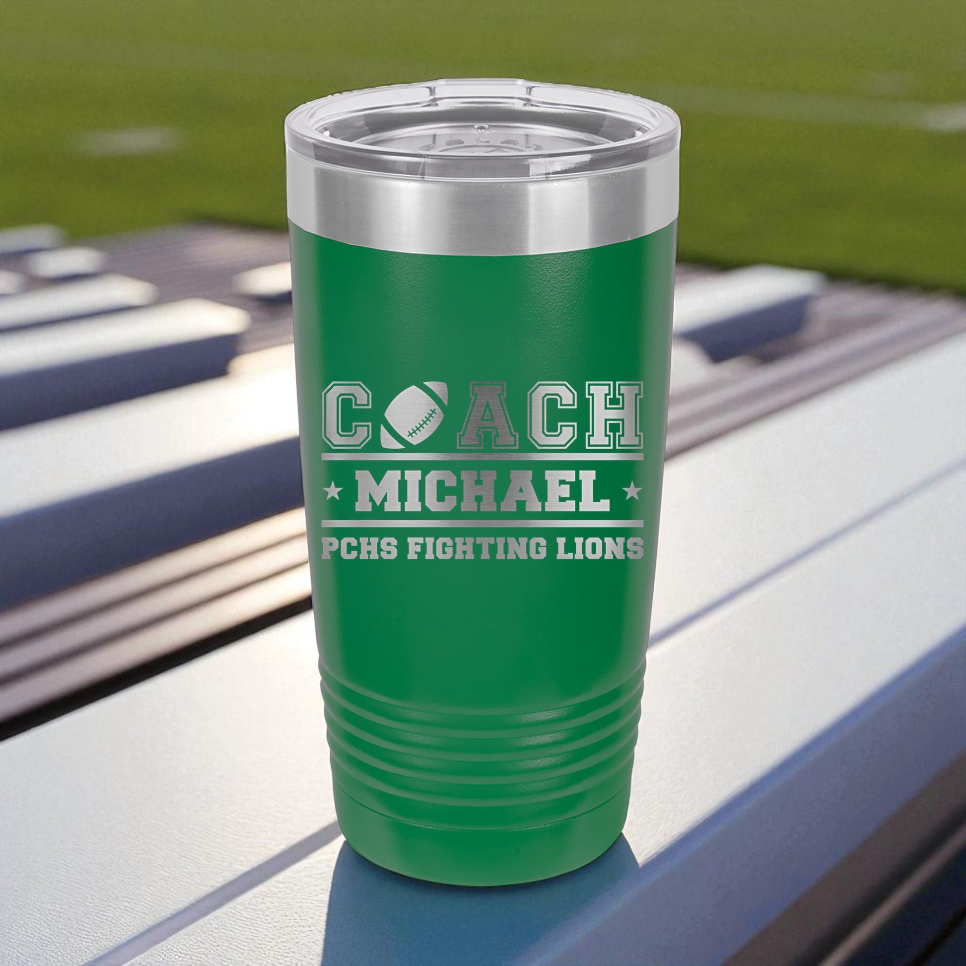 Green insulated tumbler with 'Coach Michael' and 'PCHS Fighting Lions' text on a sports field background