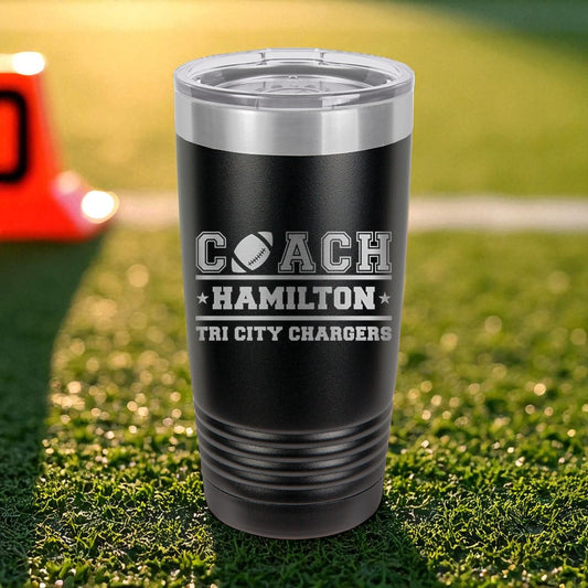 Black tumbler with 'Coach Hamilton Tri City Chargers' text on grass