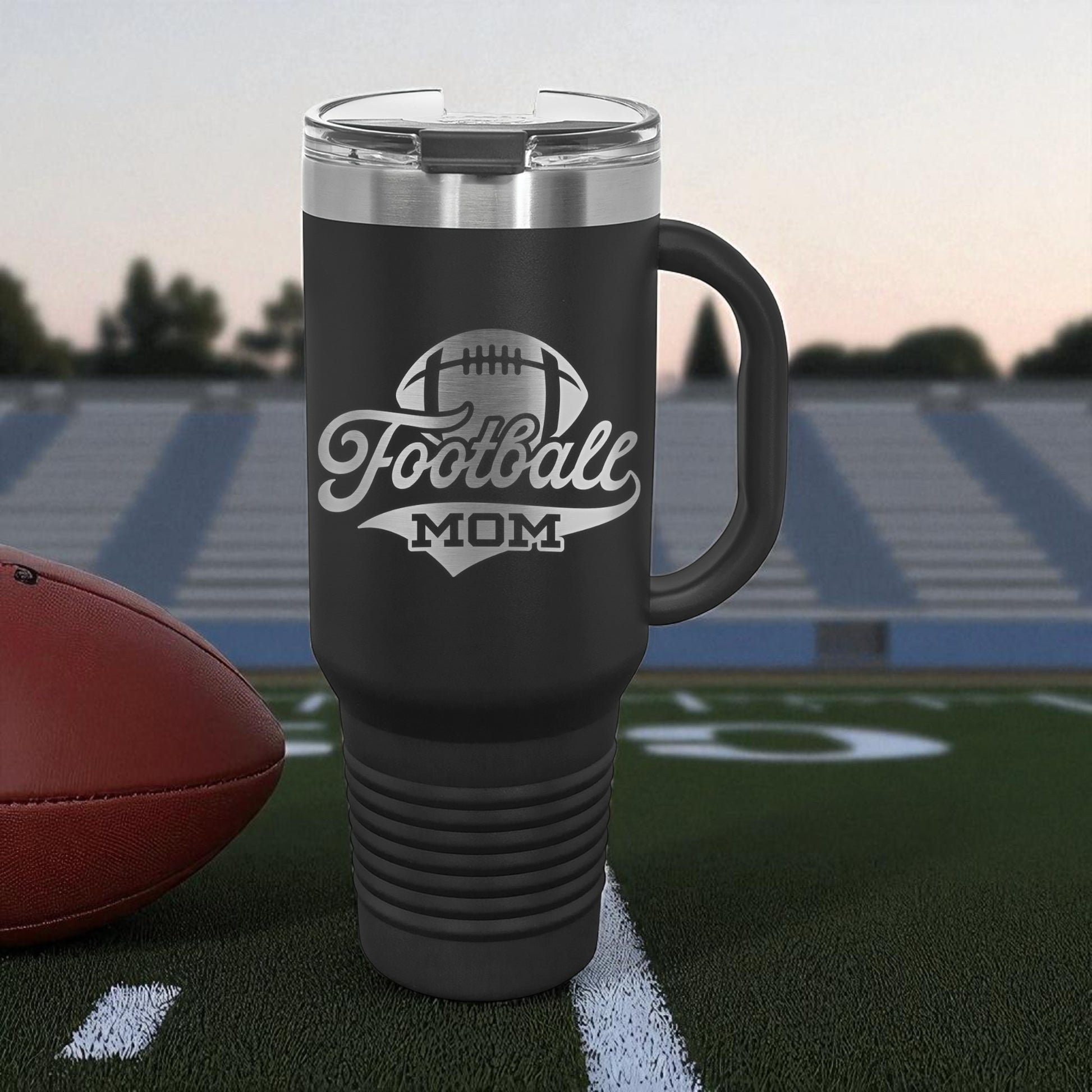 Black travel mug with 'Football Mom' text on a football field background