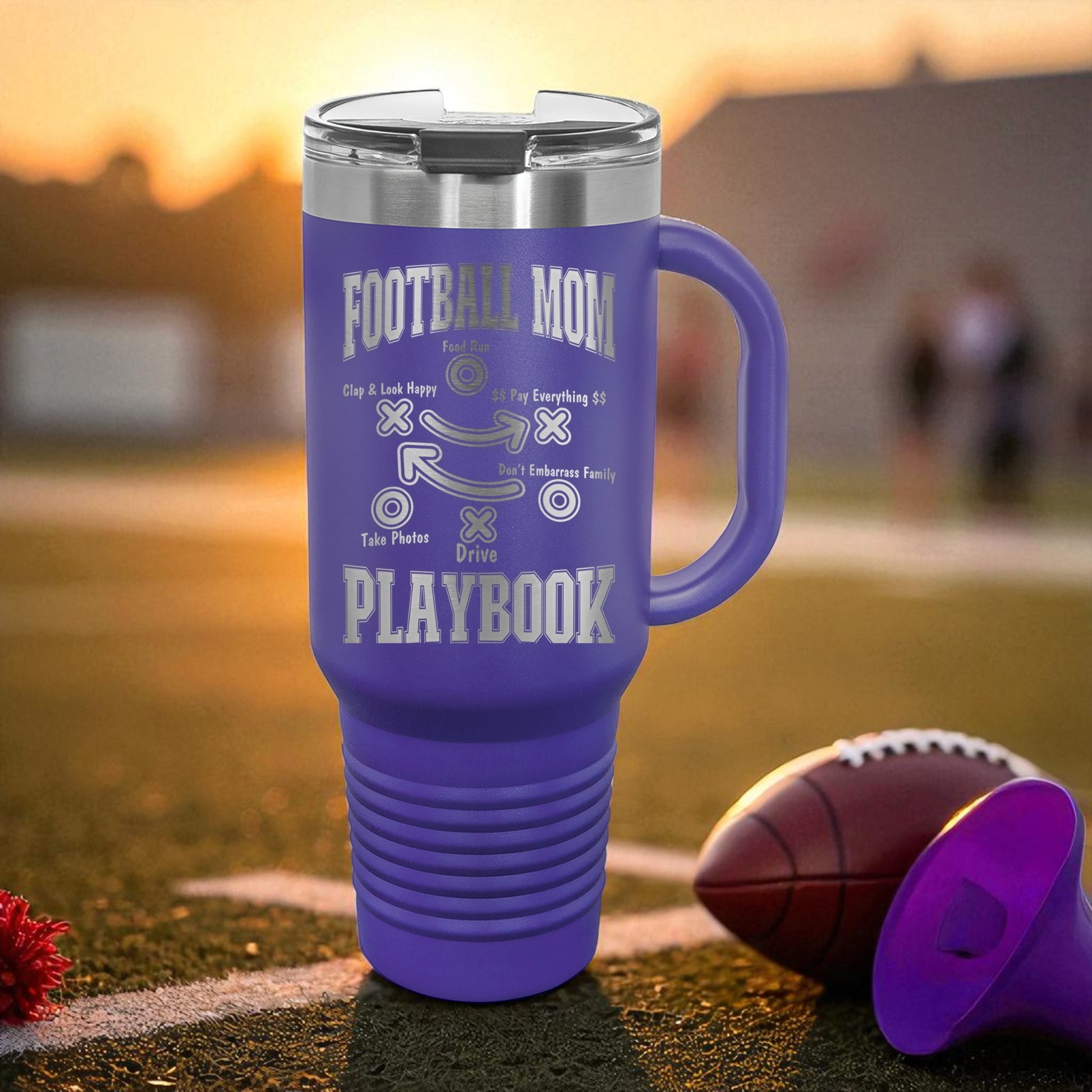 Purple travel mug with 'Football Mom' text on a football field
