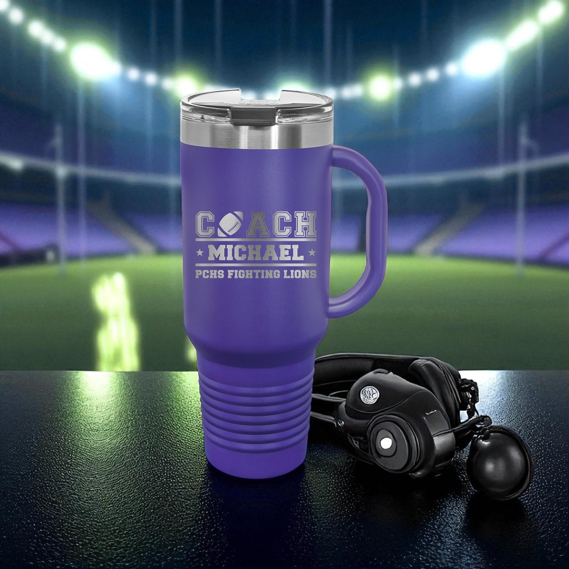 Purple travel mug with 'Coach Michael' text on a sports field background