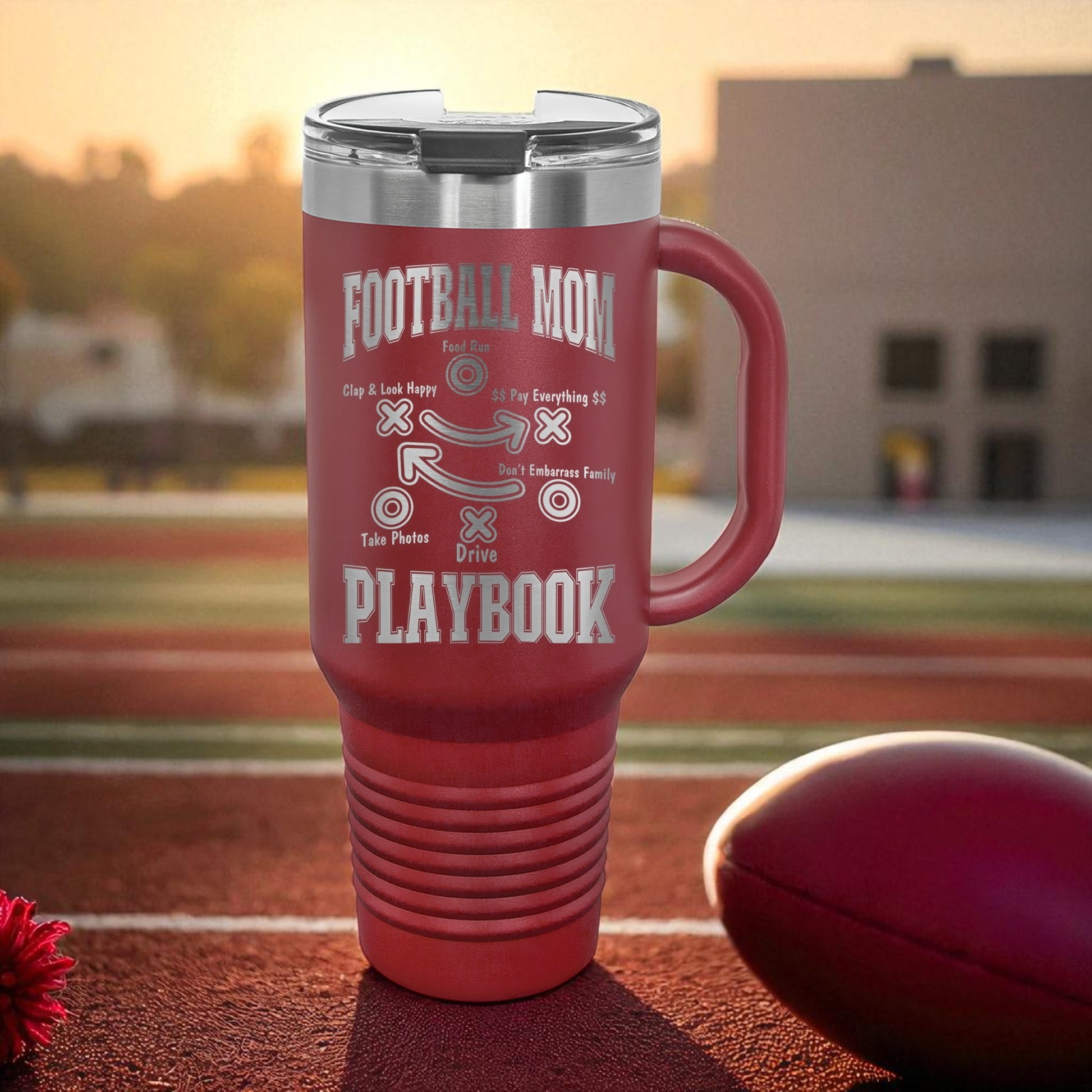 Football Mom Playbook 40oz Stanley Tumbler with Handle — laser-etched stainless steel travel mug made for Friday Night Lights, tailgates, and long tournament days. The Football Mom “Playbook” design is permanently engraved (not printed) so it won’t peel, crack, or fade. Perfect team mom gift, booster club gift, senior night gift, and everyday car cup for busy sports moms.