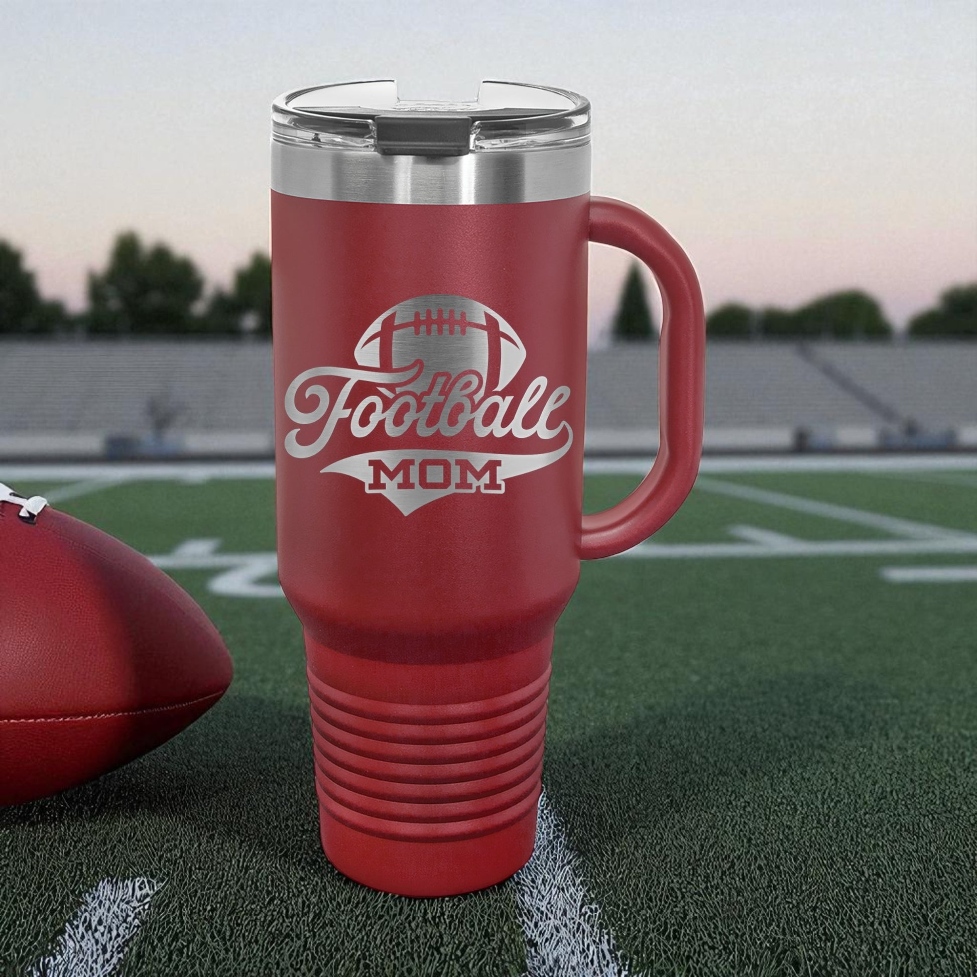 Red mug with 'Football Mom' text on a football field