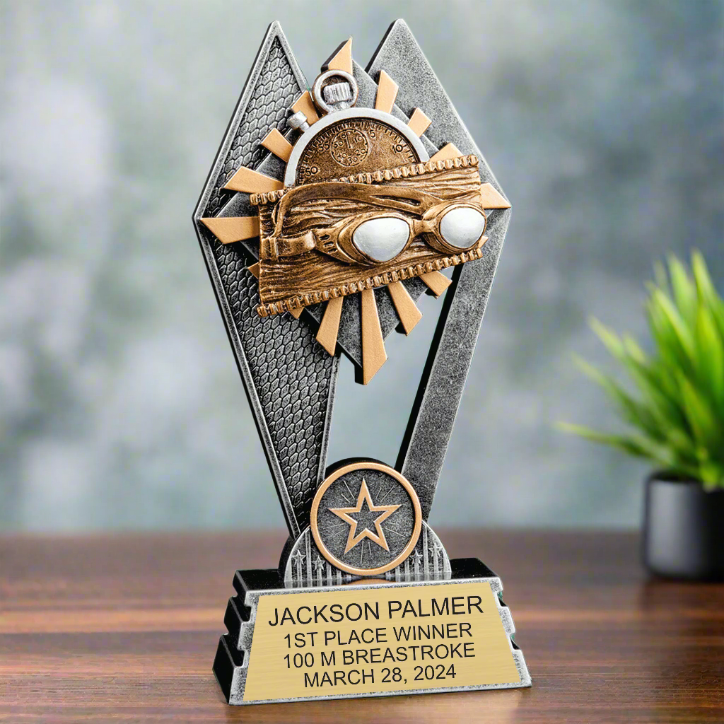 Close-up of the swimming emblem on the Swimming Sun Ray Award, featuring goggles and wave patterns in gold detail.