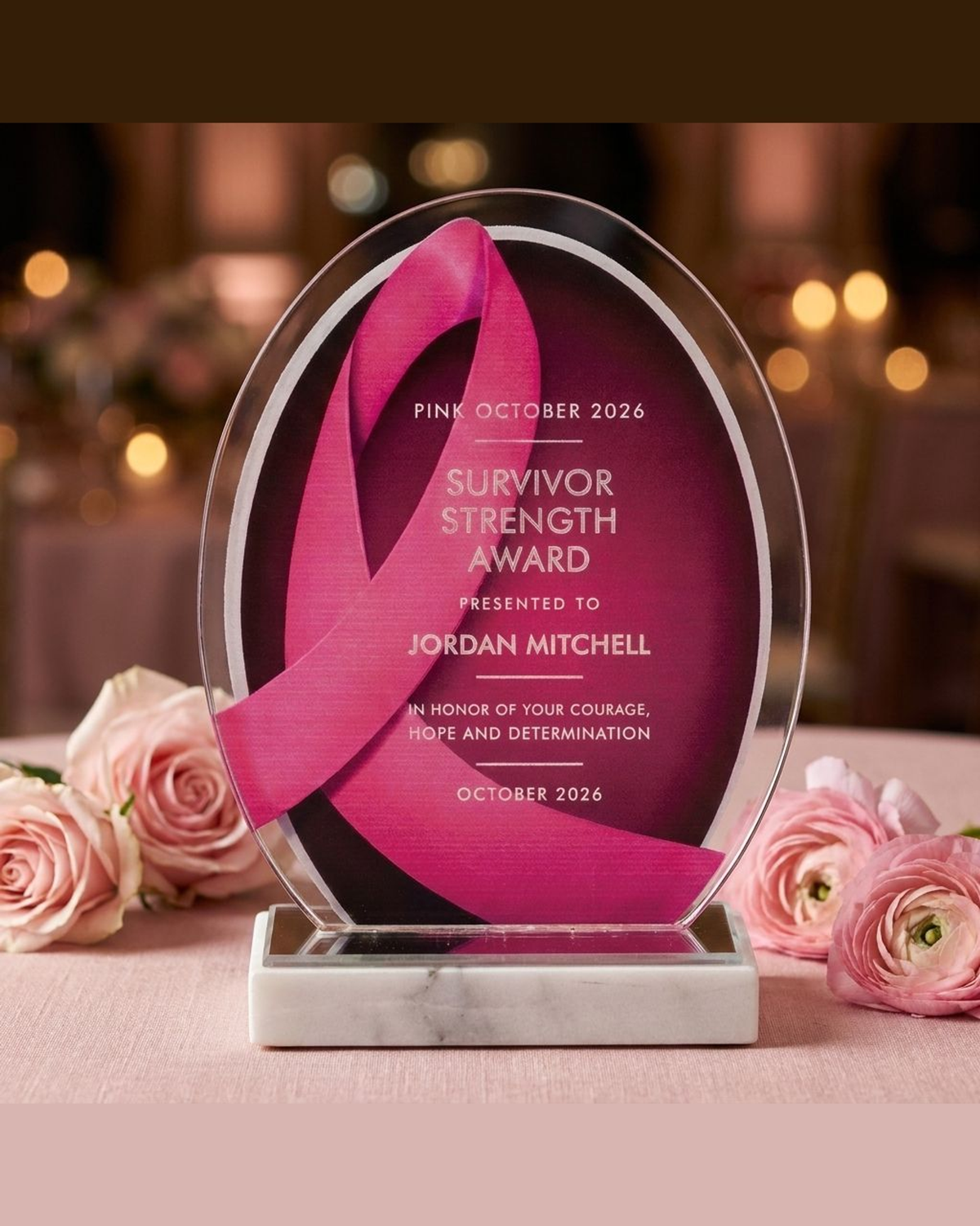 Pink ribbon breast cancer awareness acrylic award displayed on a blush-pink gala table with fresh pink flowers, personalized survivor recognition keepsake for an October awareness banquet
