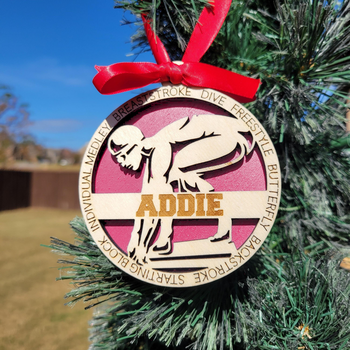 Personalized swimmer ornament with pink backing on a Christmas tree