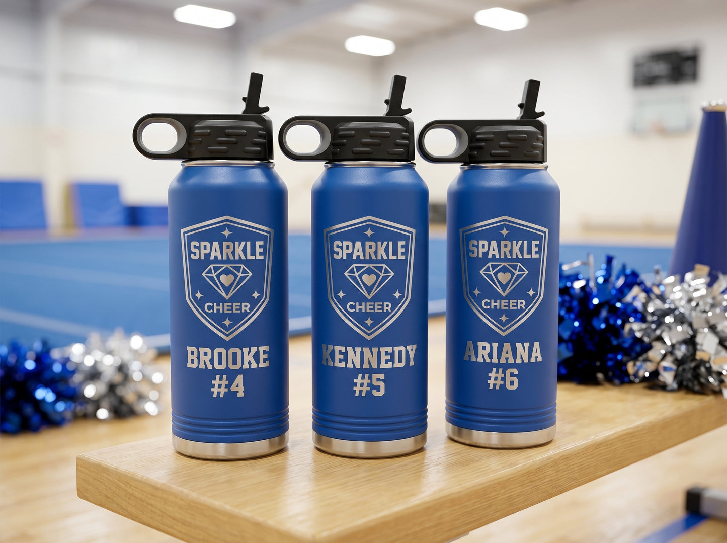 three royal blue cheer water bottles with sparkle cheer team logo and cheerleader names