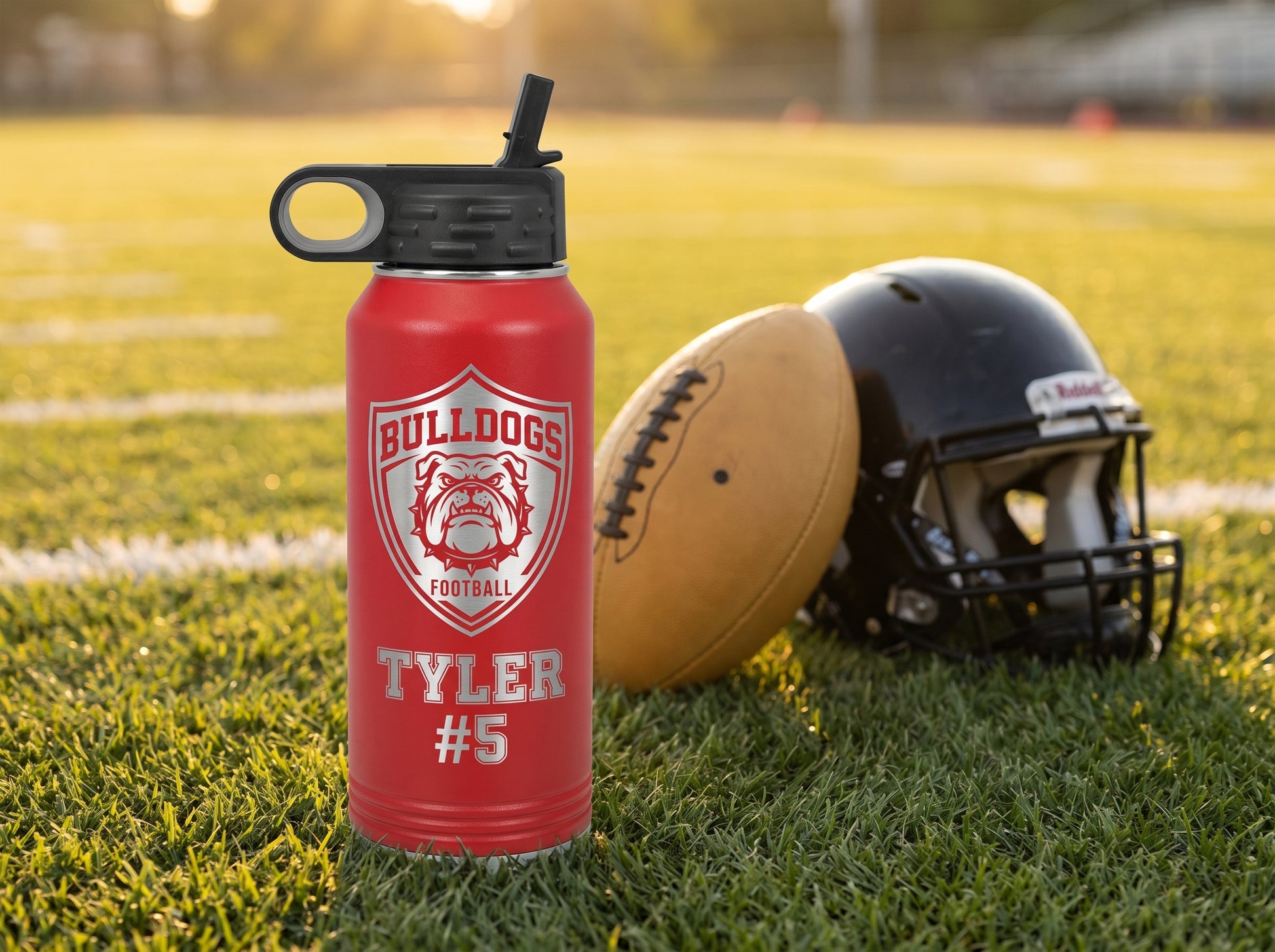 football team water bottle on practice field with football and helmet golden hour