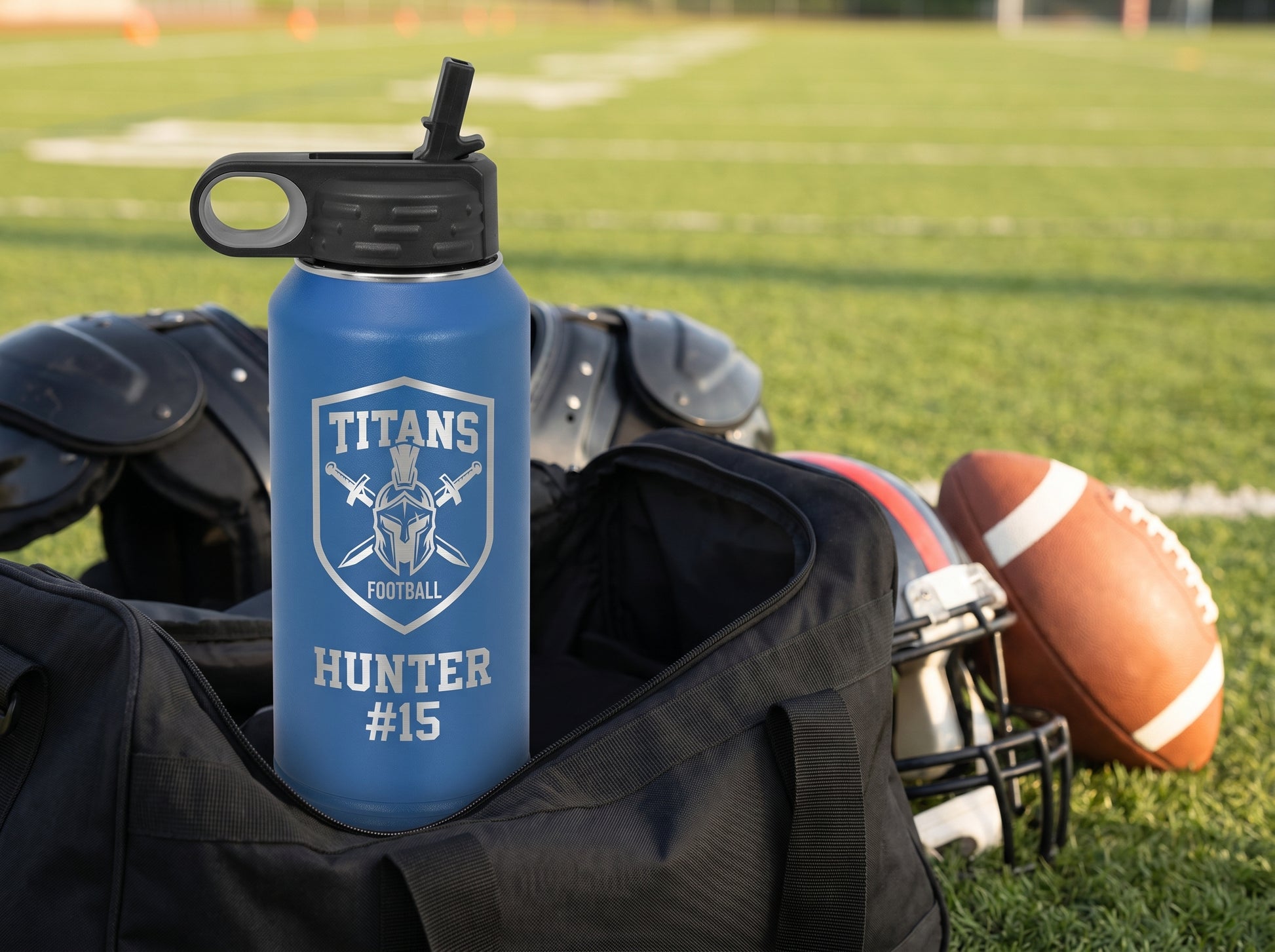royal blue football team water bottle on duffel gear bag with shoulder pads and helmet