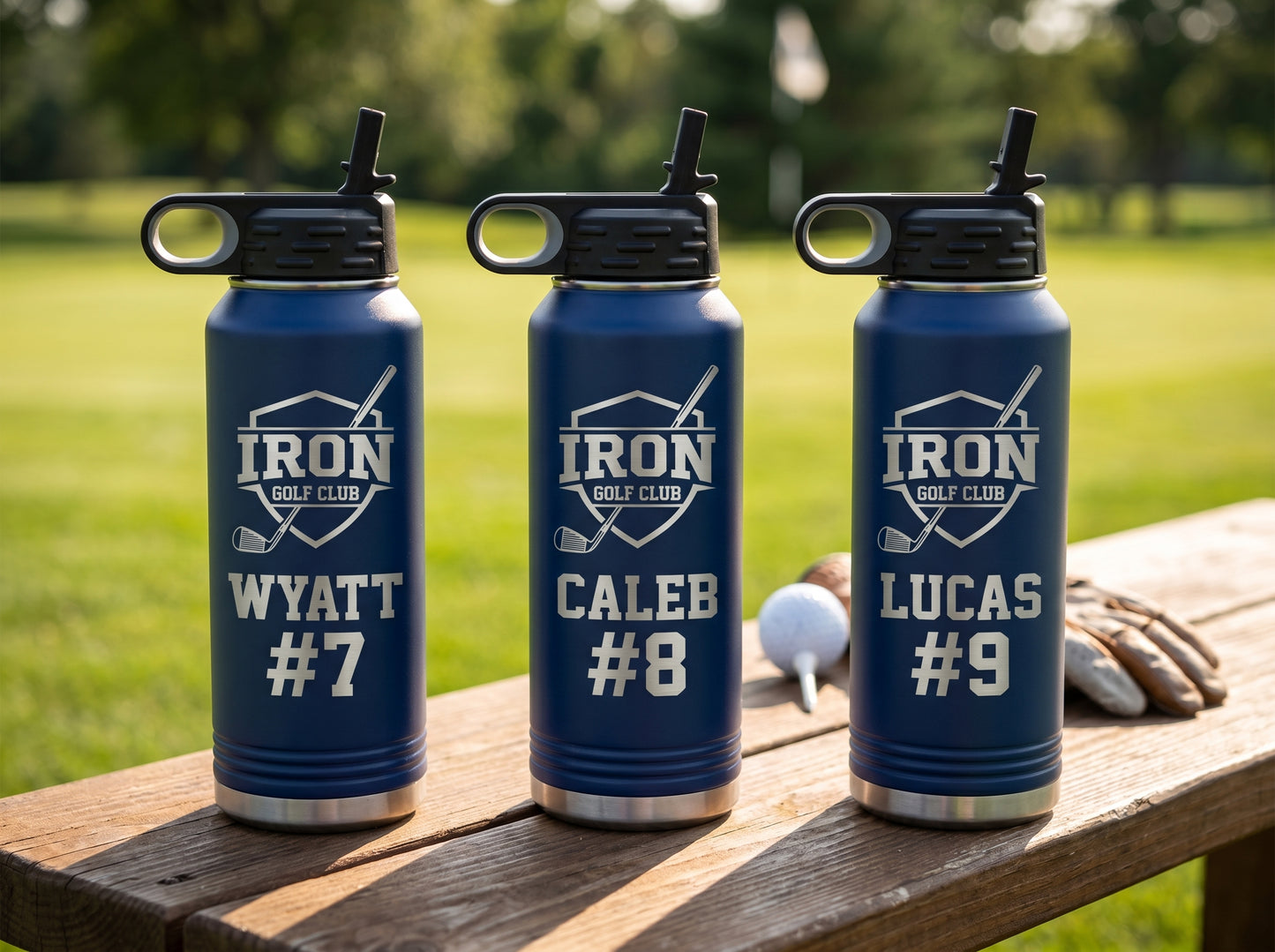 three navy blue golf team water bottles with team crest and individual golfer numbers