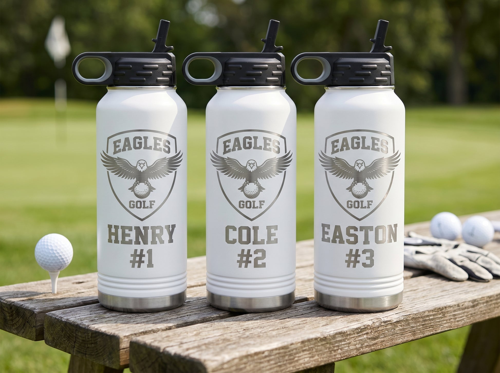 three white golf team water bottles personalized with golfer names and numbers on bench