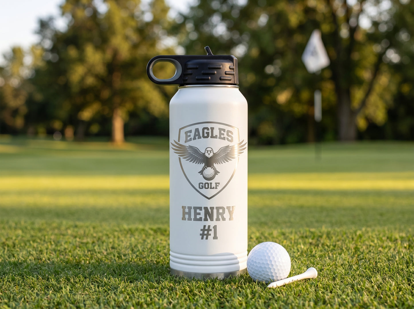 golf team water bottle on putting green with golf ball and tee golden hour