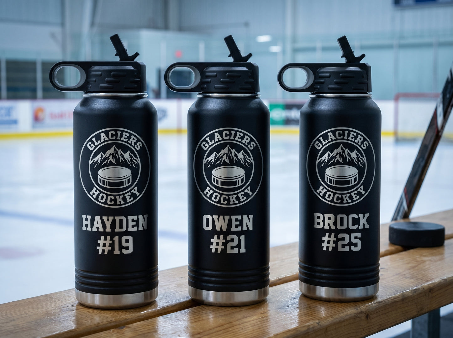 three black hockey team water bottles with team crest and individual player jersey numbers