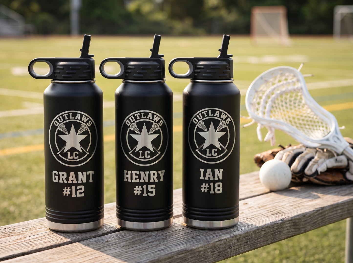 three black lacrosse team water bottles with team crest and individual player jersey numbers