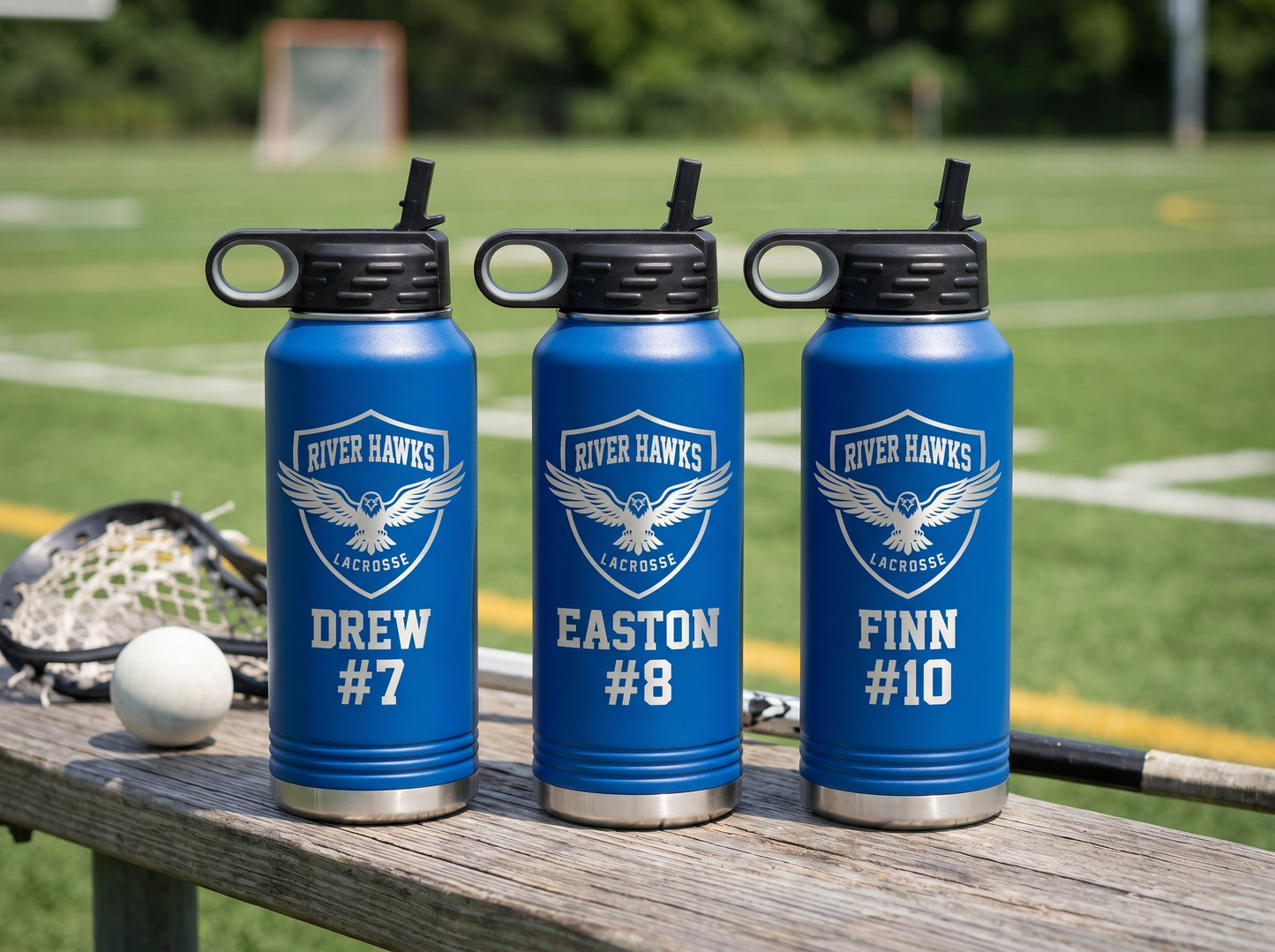 three royal blue lacrosse water bottles with team logo and player names lined up on bench
