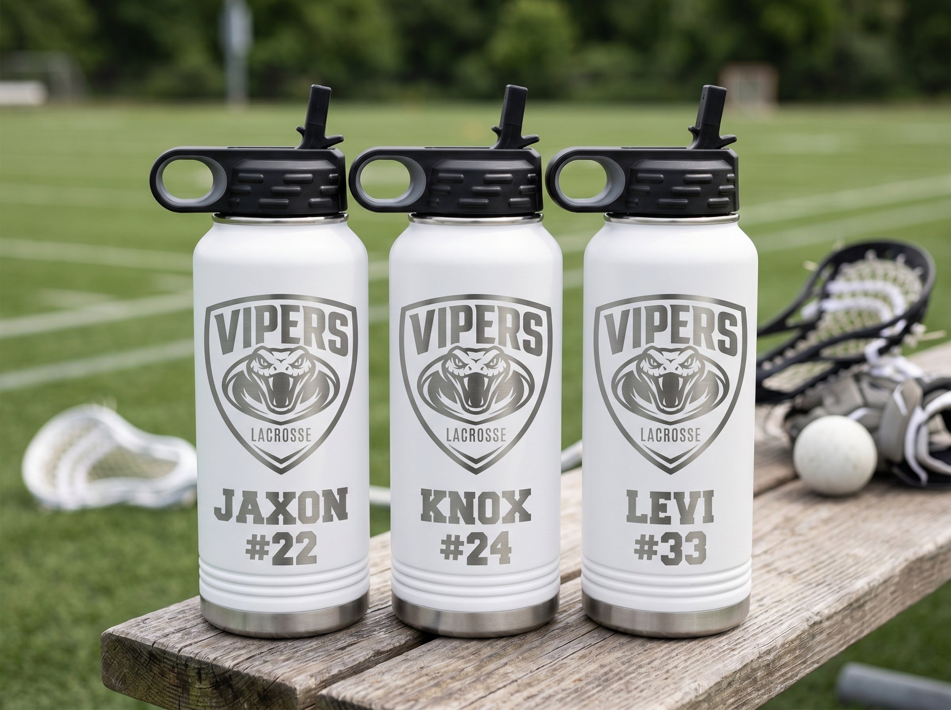 three white lacrosse team water bottles personalized with player names and numbers for team roster
