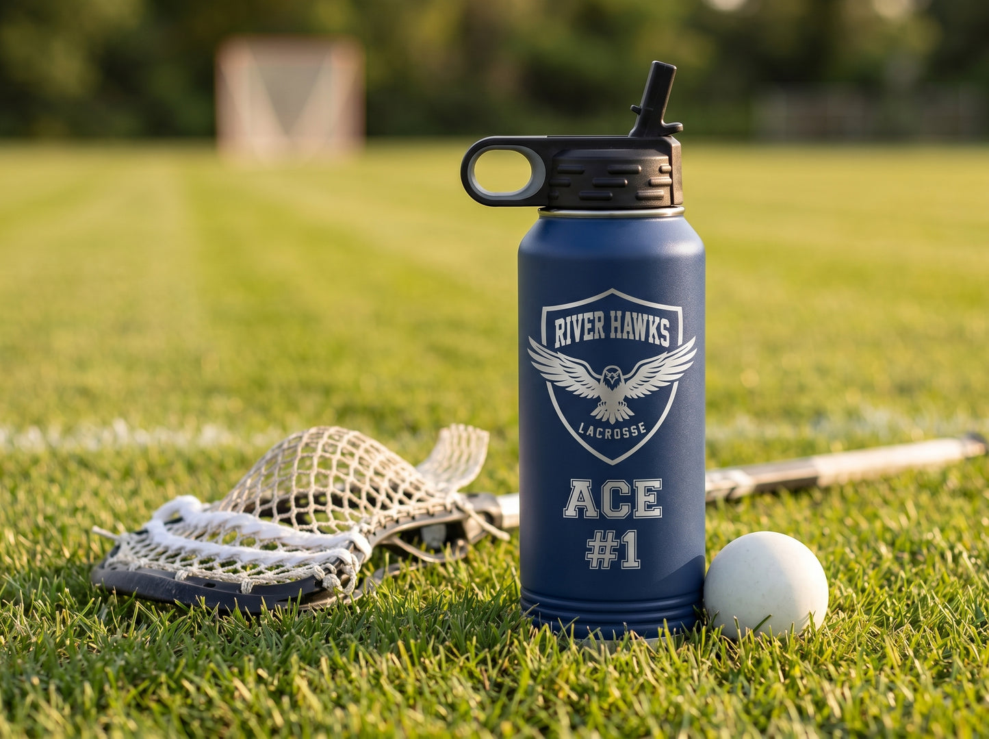 lacrosse team water bottle on grass with stick and ball at base golden hour field