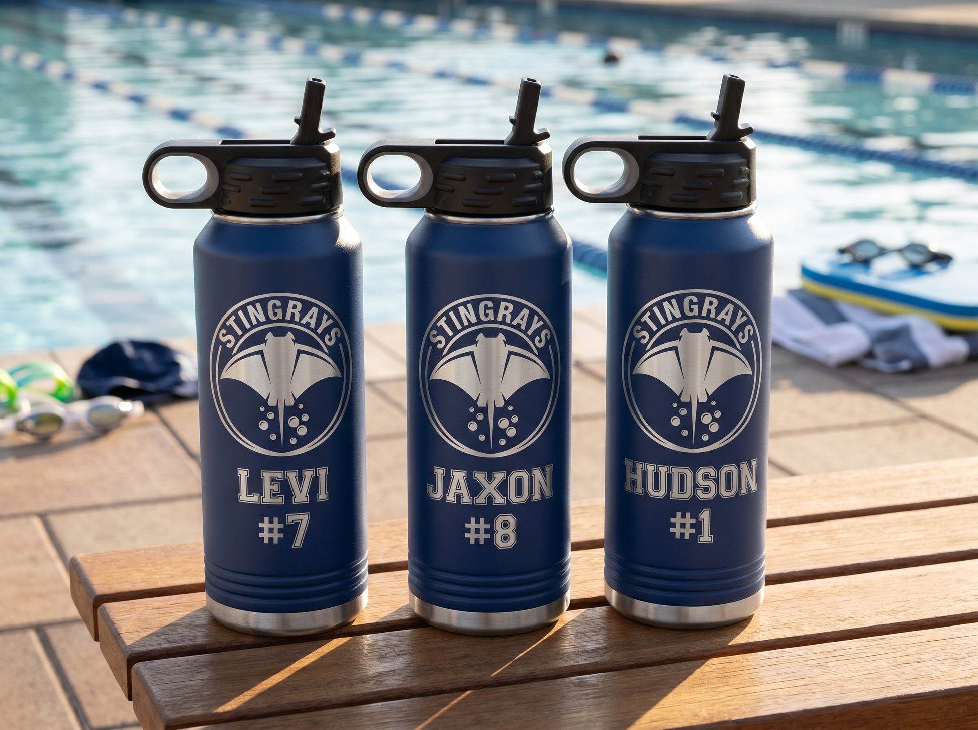 three navy blue swim team water bottles with stingrays crest personalized swimmer names