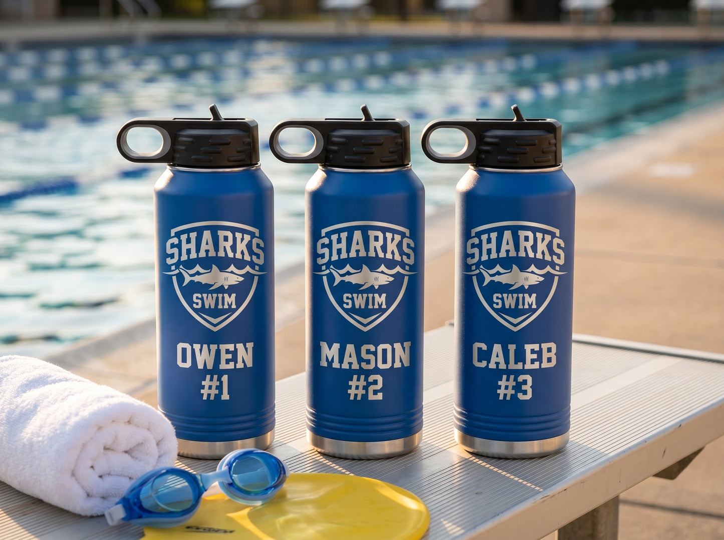 three royal blue swim team water bottles personalized with swimmer names and lanes on bench