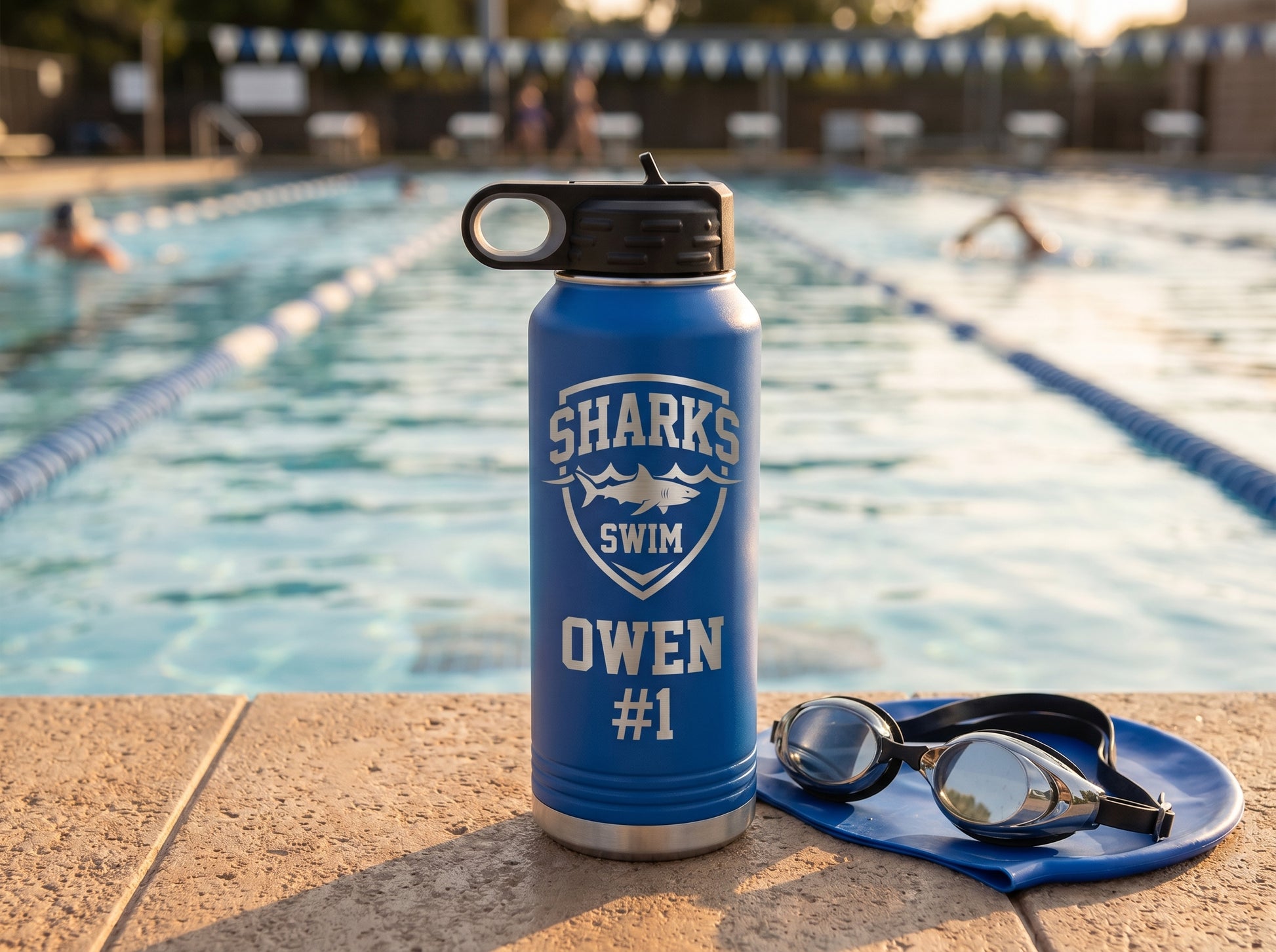 swim team water bottle on pool deck with goggles and swim cap golden hour lane ropes