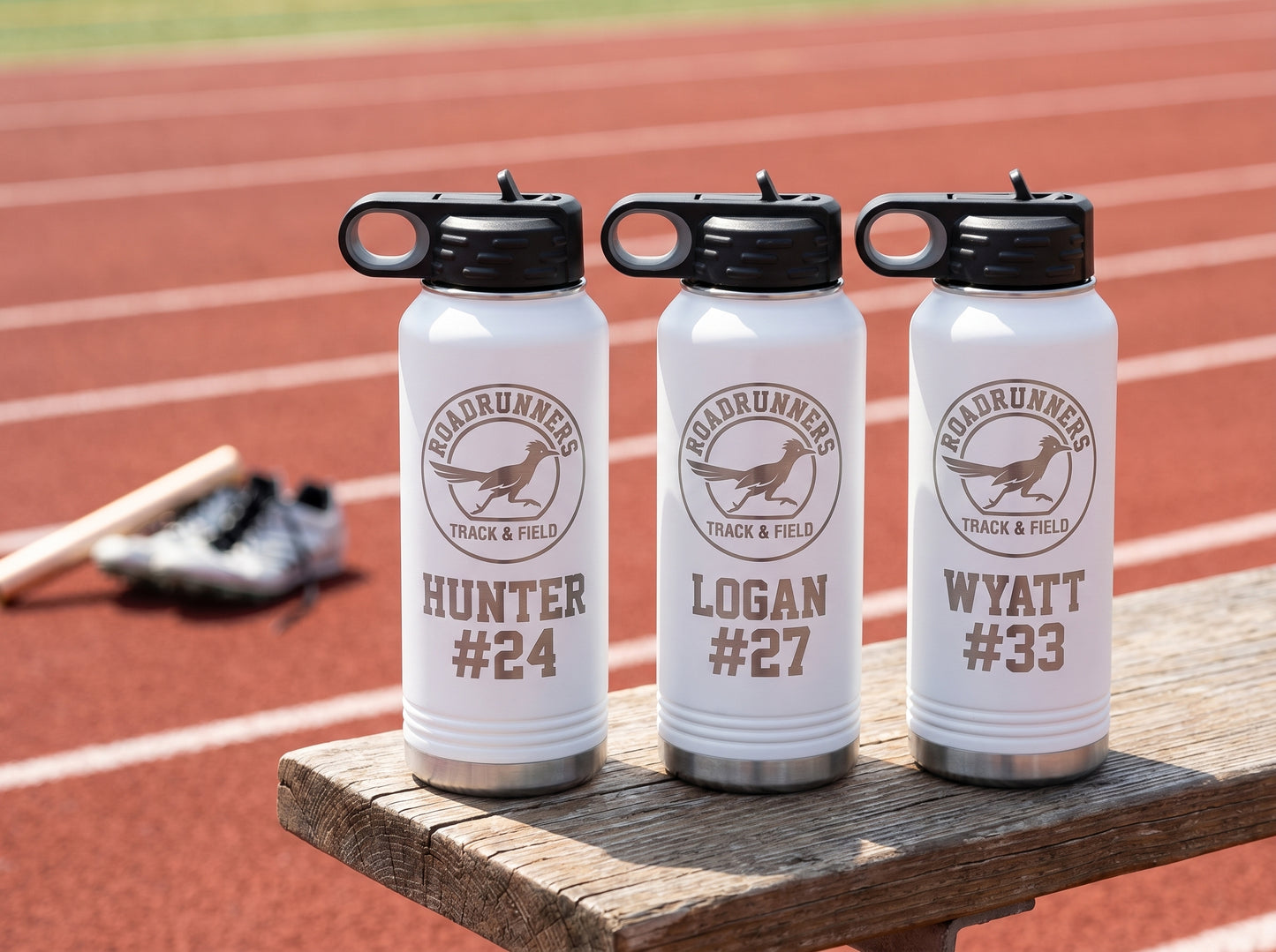 three white track team water bottles personalized with runner names and numbers for team roster