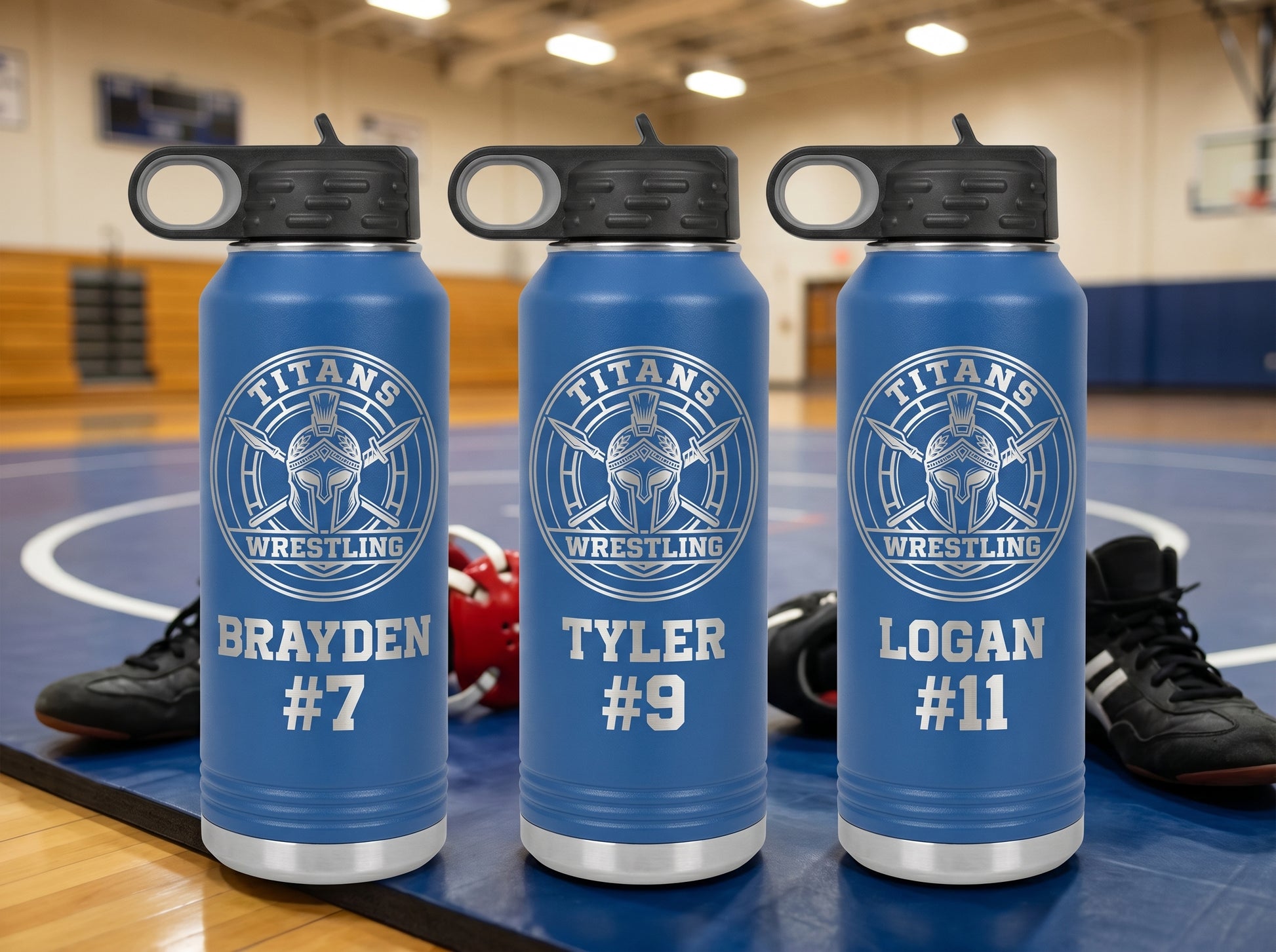 three royal blue wrestling water bottles with titans team logo and wrestler names on mat