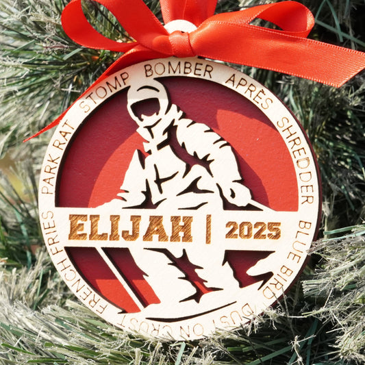 Decorative ornament with a red ribbon on a Christmas tree, featuring text and graphics.