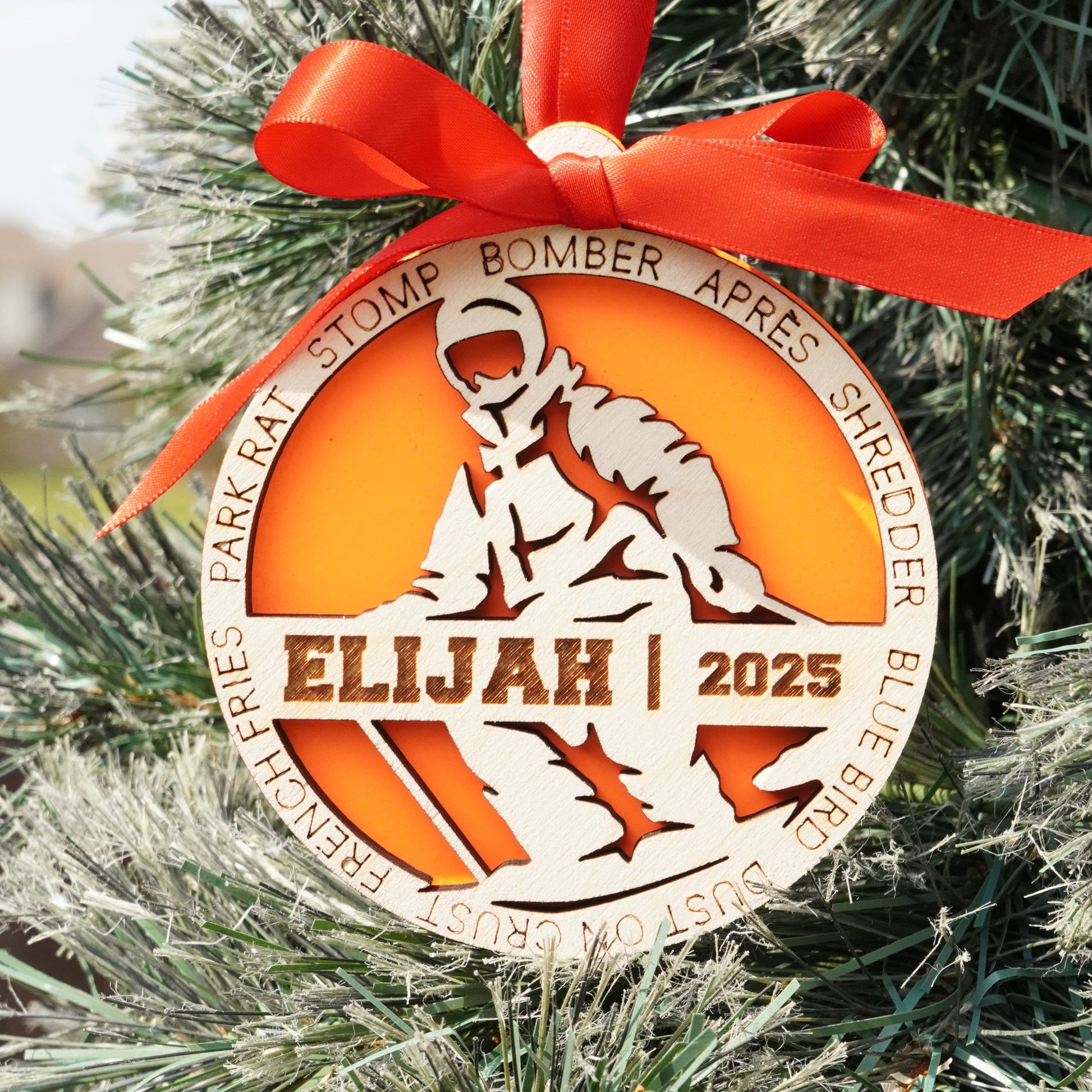 Decorative ornament with 'Elijah 2025' on a Christmas tree