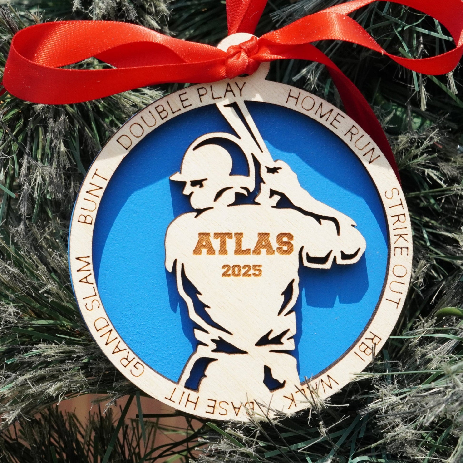 Decorative ornament with a baseball player design on a Christmas tree.