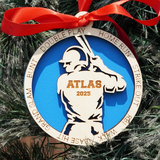 Decorative ornament with a baseball player design on a Christmas tree.