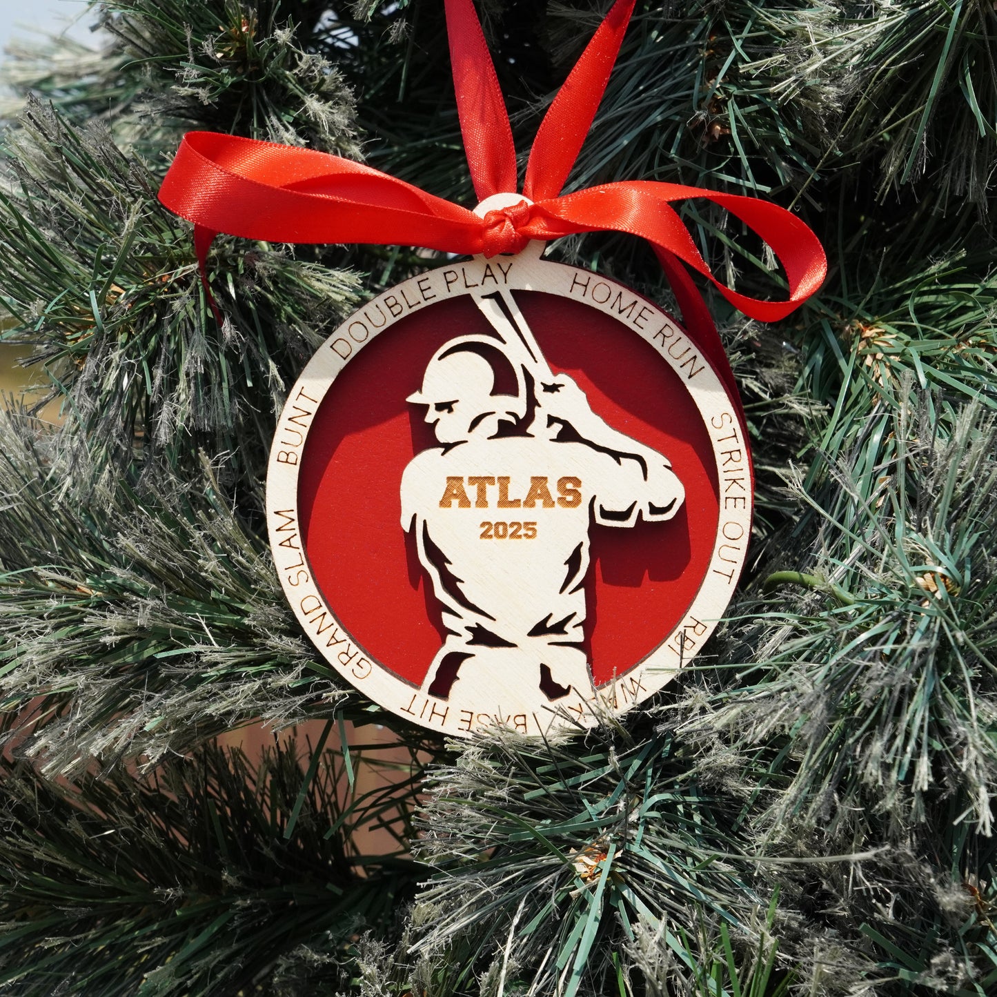 Decorative ornament with a red ribbon on a Christmas tree, featuring the word 'Atlas' and numbers.