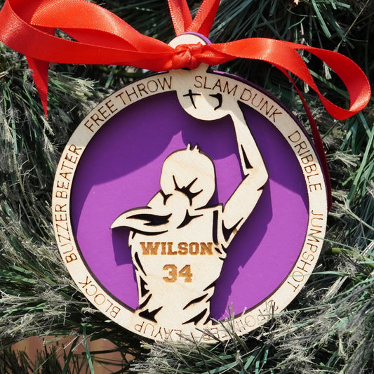 Ornament with basketball player design and 'Wilson 34' text on a purple background, tied with a red ribbon.