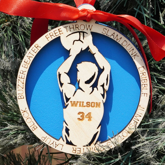 Basketball-themed ornament with a red ribbon on a Christmas tree