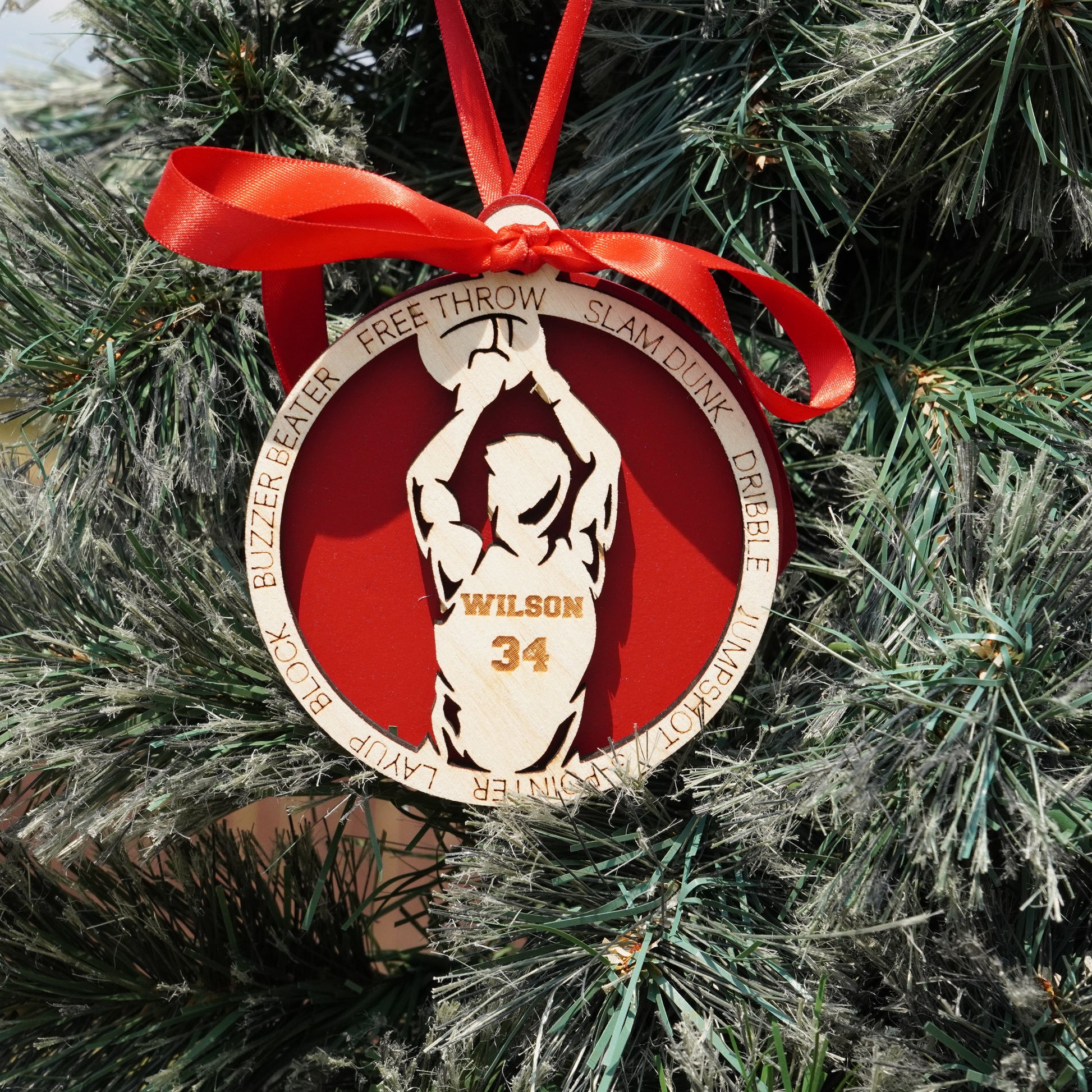 Basketball-themed ornament with red ribbon on a Christmas tree