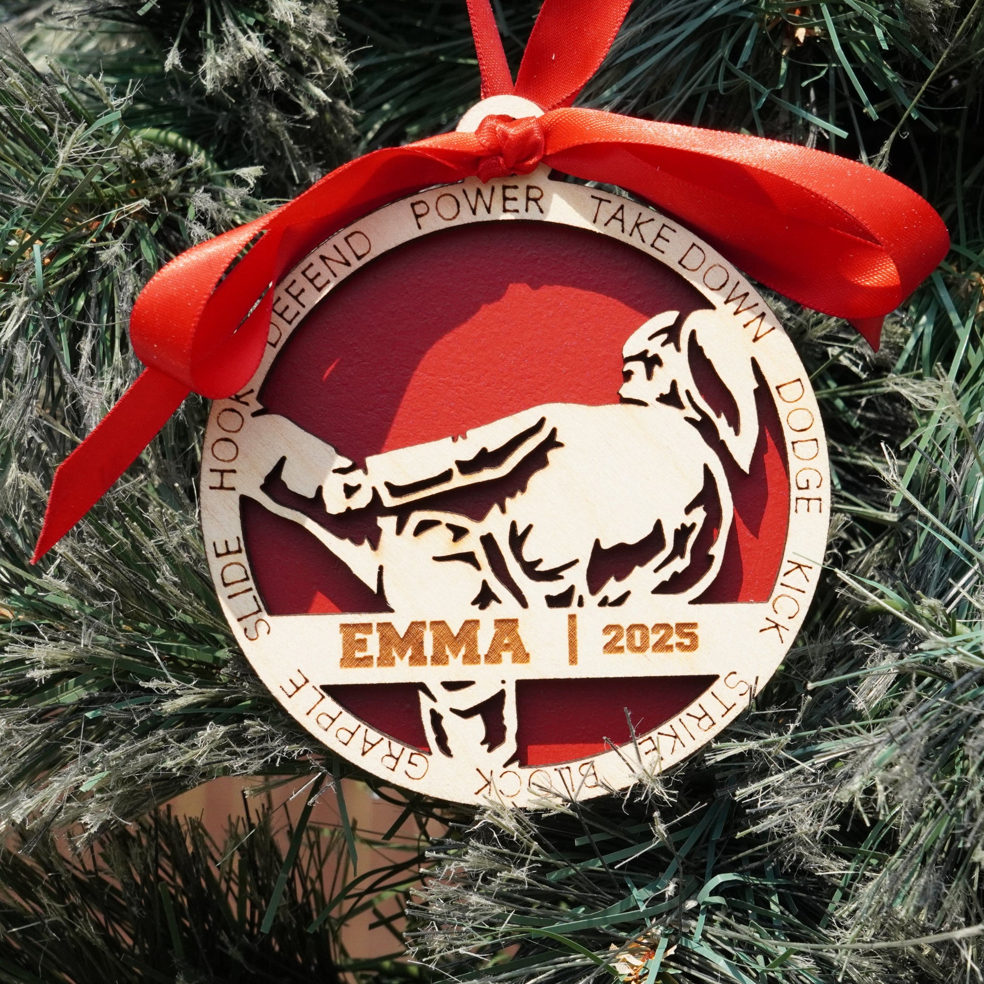 Decorative Christmas ornament with a red ribbon on a tree, featuring a bull and text.