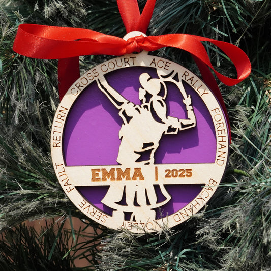 Decorative ornament with a purple and gold design on a Christmas tree.