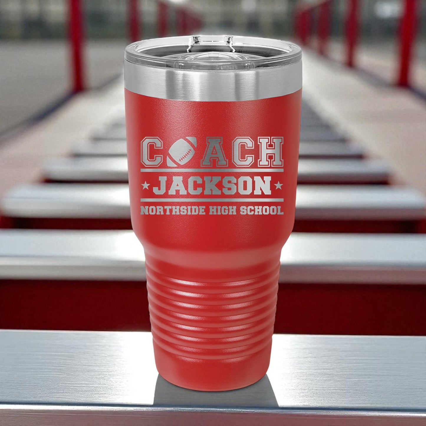 Red tumbler with 'Coach Jackson' and 'Northside High School' text on a metal surface.