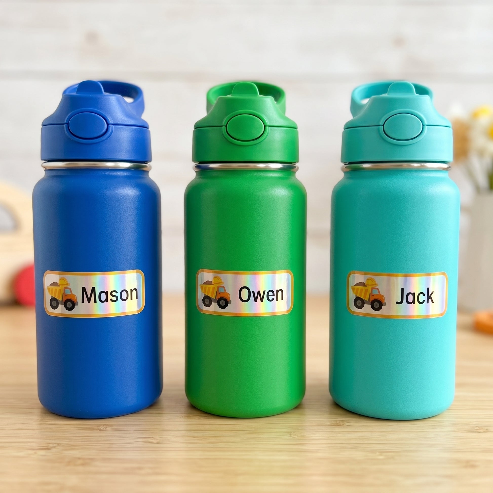 Personalized construction name labels on three kids water bottles