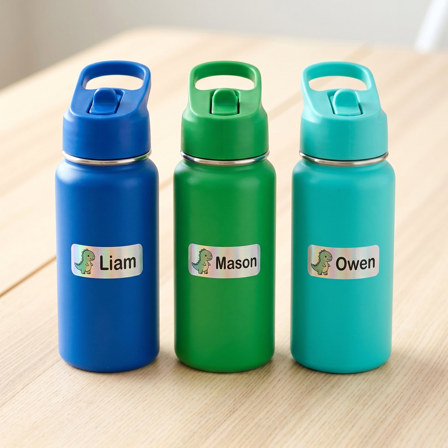 Personalized dinosaur name labels on three kids water bottles