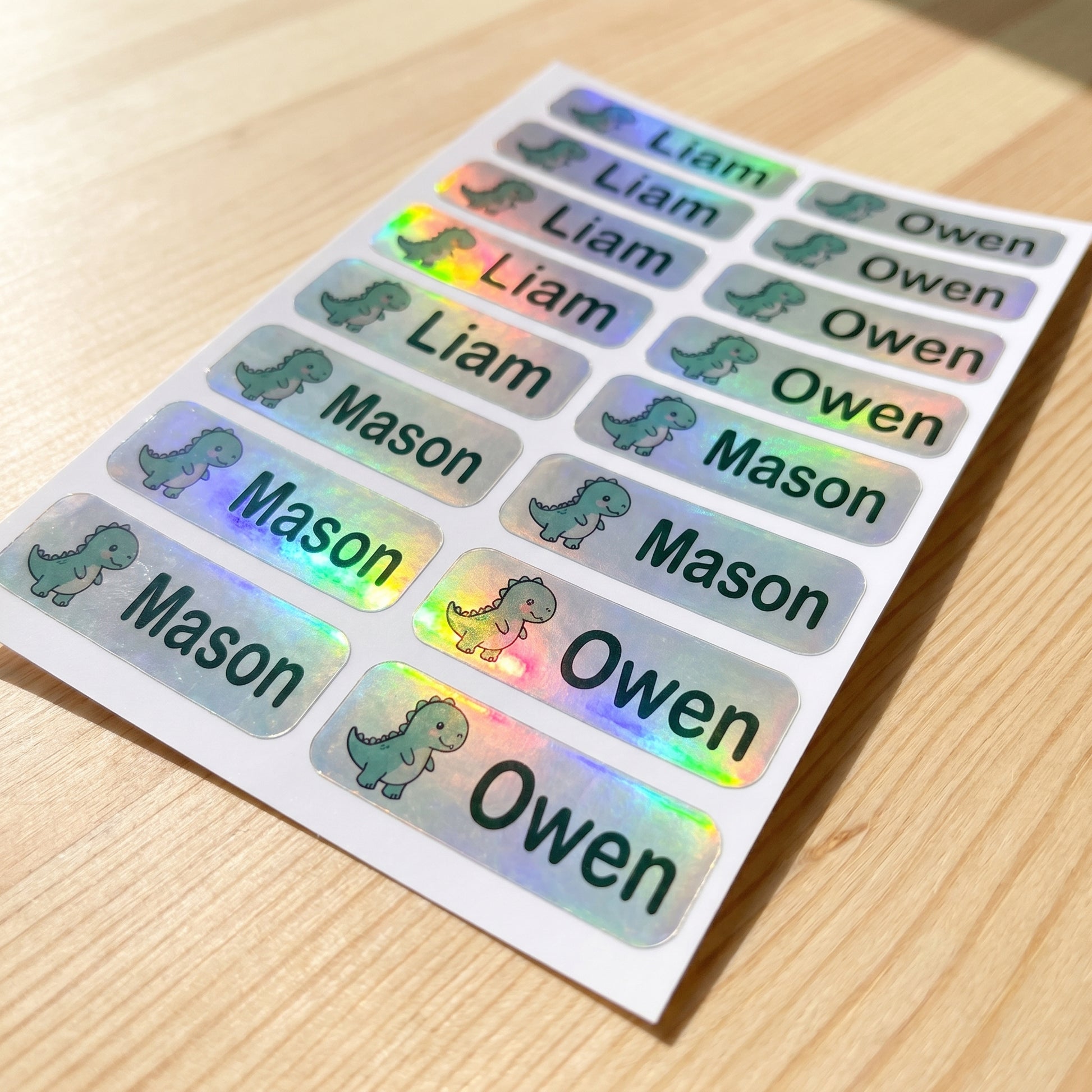 Holographic dinosaur name label sticker sheet close-up with rainbow shimmer