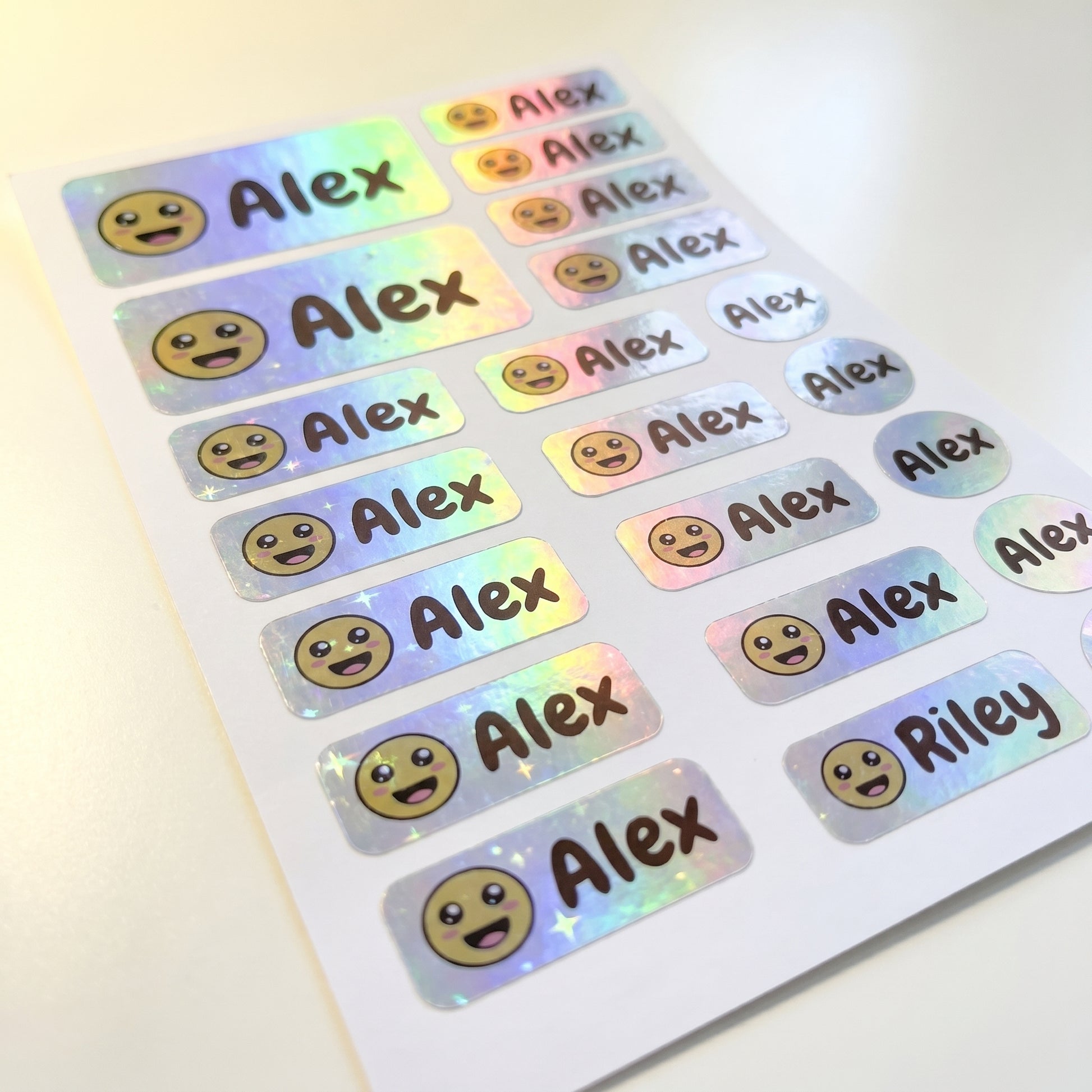 Holographic smiley name label sticker sheet close-up with rainbow shimmer