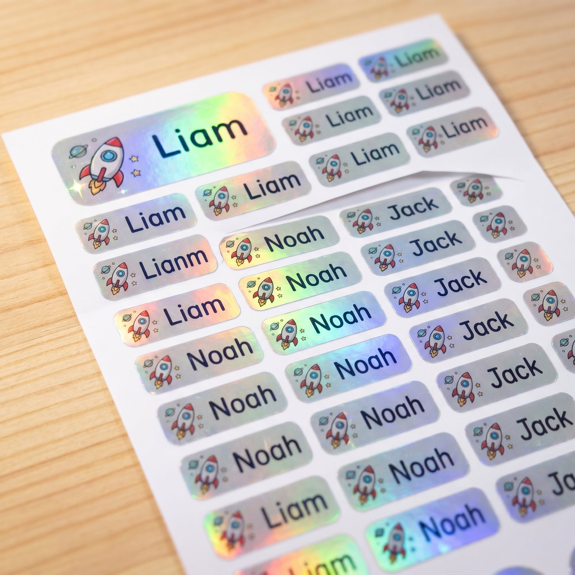 Holographic space name label sticker sheet close-up with rainbow shimmer
