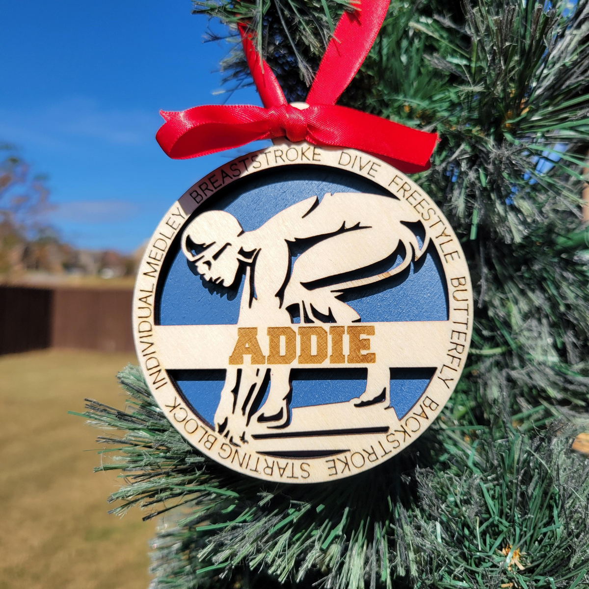 Personalized swimmer ornament with blue backing on a Christmas tree