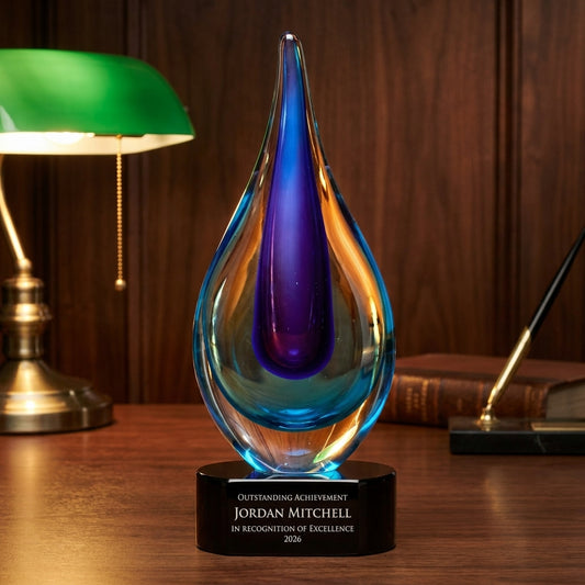 Personalized Blue art glass award on a warm executive desk with a green banker's lamp, engraved corporate recognition and retirement gift