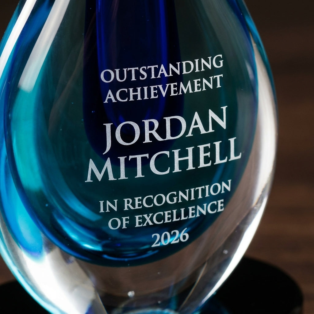 Close-up of the custom laser engraving on a personalized Blue art glass award, showing crisp permanent personalization