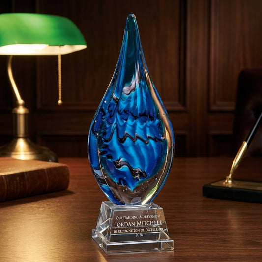 Personalized Flame Blue art glass award on a warm executive desk with a green banker's lamp, engraved corporate recognition and retirement gift