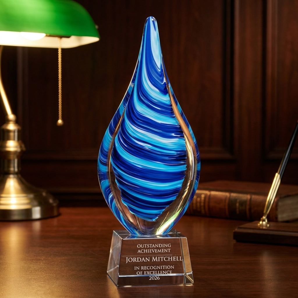 Personalized Flame Blue art glass award on a warm executive desk with a green banker's lamp, engraved corporate recognition and retirement gift